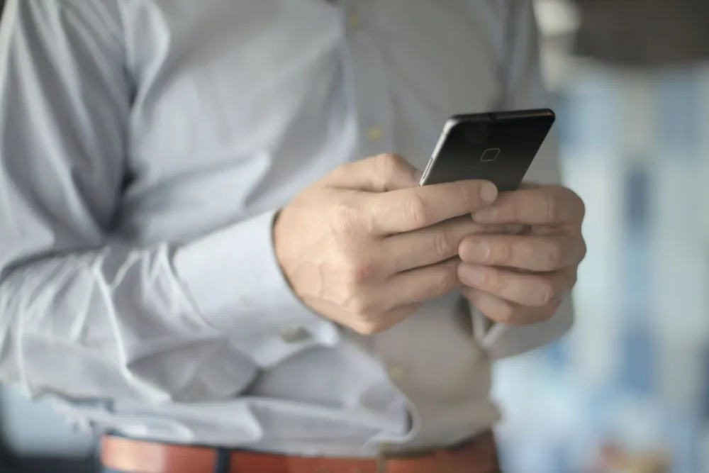 Colaborador de seguridad privada sosteniendo un smartphone