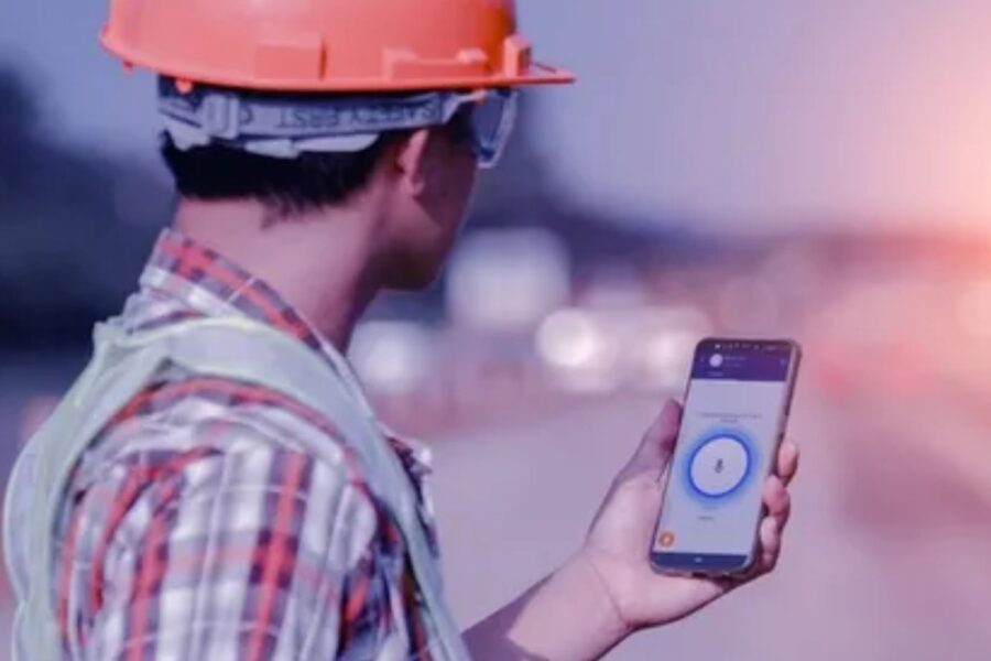 engenheiro com celular na mão ouvindo áudio