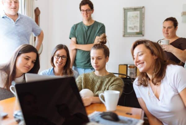 team debating in front of a laptop