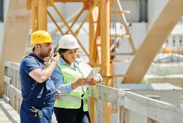 duas pessoas em uma obra com rádio comunicadores
