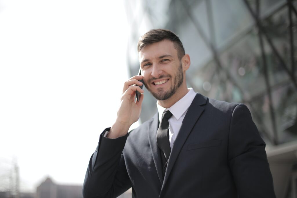 Homem sorri ao segurar celular próximo a orelha, inteligência situacional e tecnologia