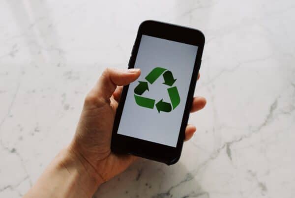CELULAR COM SÍMBOLO DE RECICLAGEM VERDE, INDICA ESG