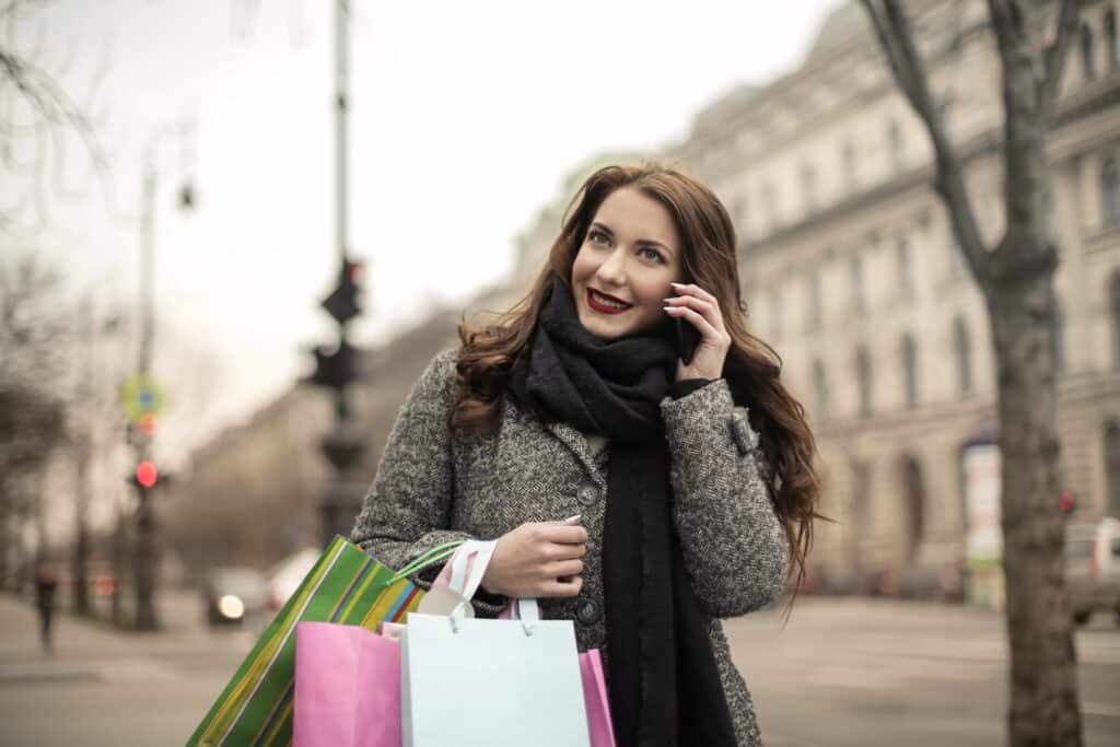 mulher fazendo compras no varejo e usa push to talk no celular